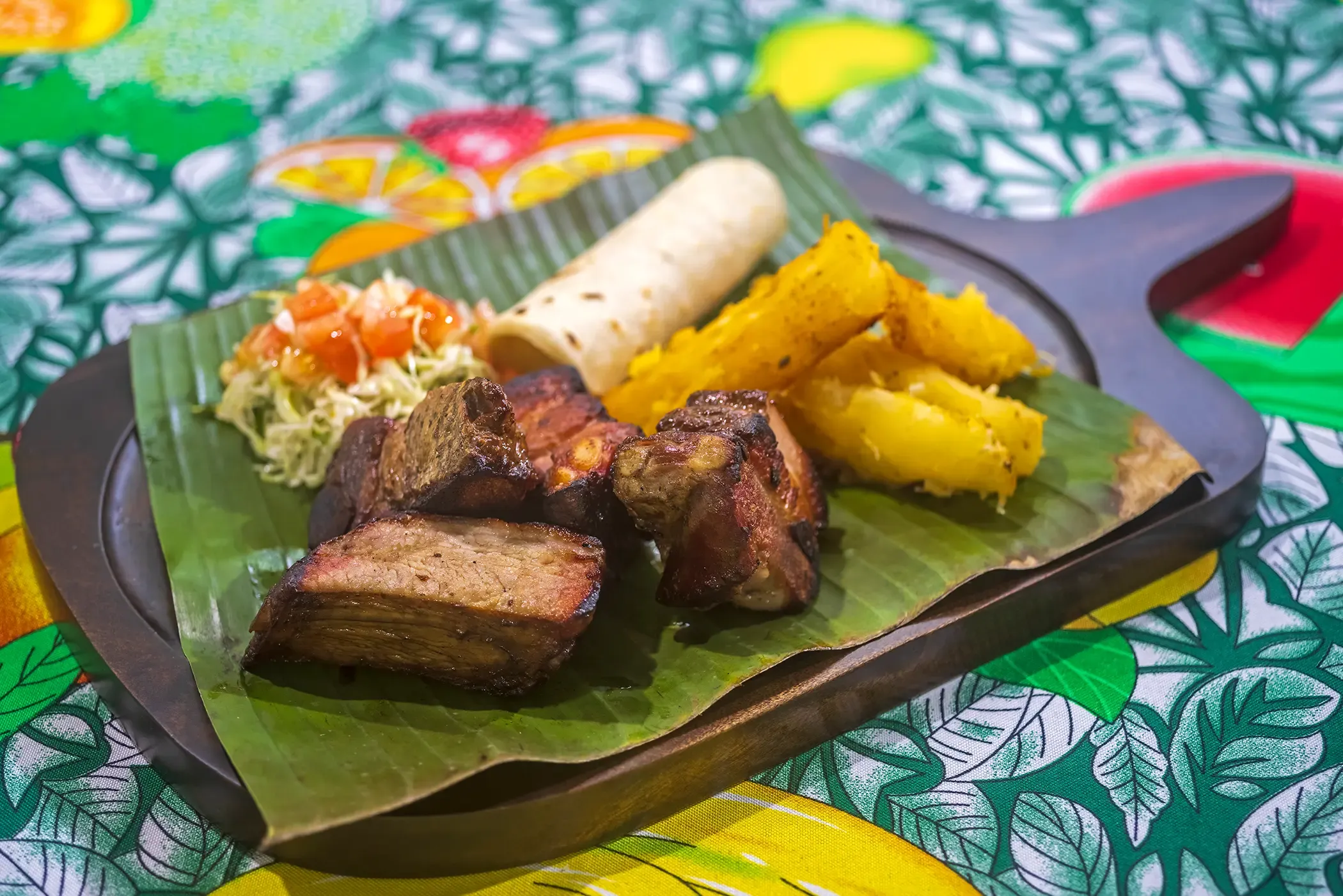 Chicharrón mit Maniok auf einem Bananenblatt serviert